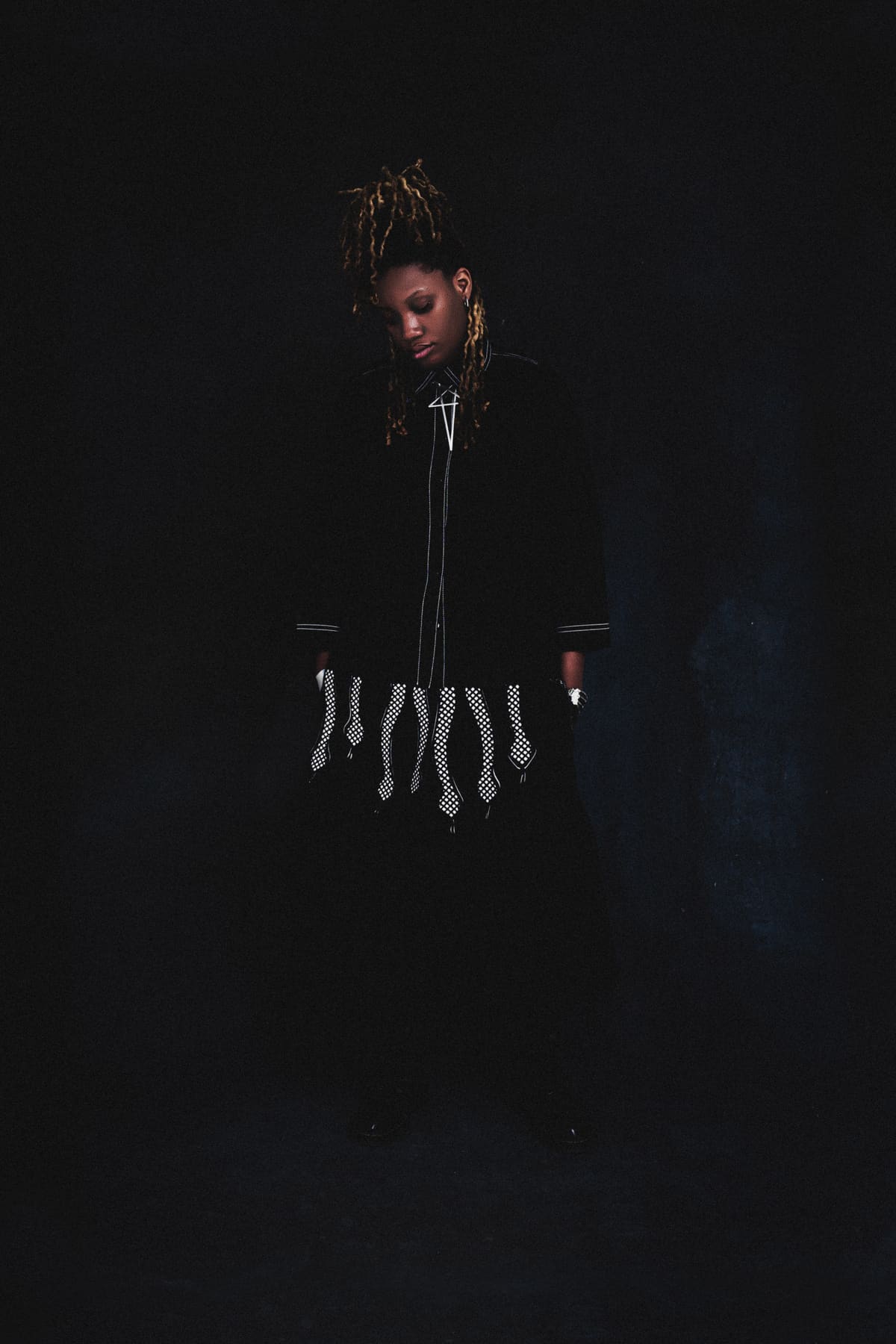 Aniko standing in black and looking downward